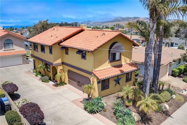 375 N 6th St, Grover Beach, CA 93433 - mediterranean / spanish home featuring an attached garage, stucco siding, a tile roof, and driveway