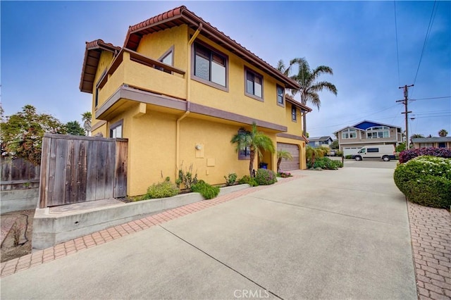 375 N 6th St, Grover Beach, CA 93433 - view of home's exterior featuring a balcony, concrete driveway, stucco siding, and a tile roof