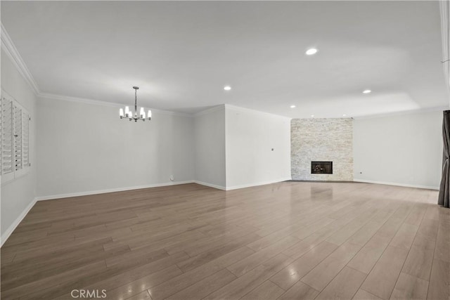 12355 Chandler Blvd Unit 101, Valley Village, CA 91607 - unfurnished living room featuring a chandelier, wood finished floors, a stone fireplace, crown molding, and recessed lighting