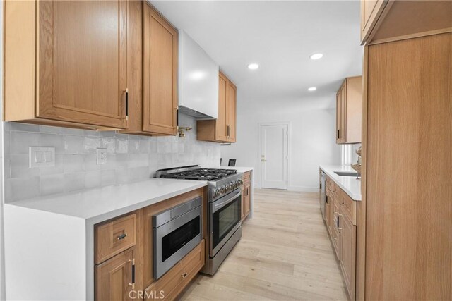 6611 Pickett Ave, Garden Grove, CA 92845 - kitchen with stainless steel appliances, light wood-style flooring, light countertops, decorative backsplash, and recessed lighting