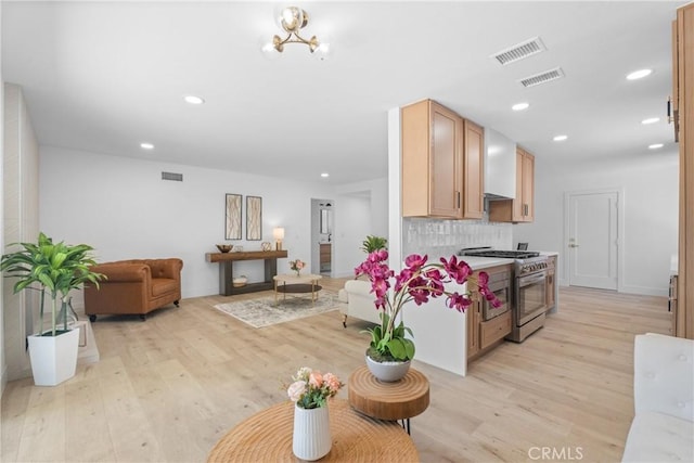 6611 Pickett Ave, Garden Grove, CA 92845 - kitchen featuring high end range, open floor plan, light wood-style flooring, recessed lighting, and decorative backsplash