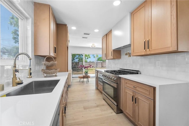 6611 Pickett Ave, Garden Grove, CA 92845 - kitchen with stainless steel stove, light wood-style flooring, recessed lighting, light countertops, and decorative backsplash