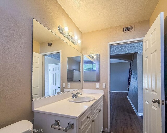 16702 Canoe Cv, Moreno Valley, CA 92551 - bathroom featuring a textured wall, vanity, wood finished floors, and a textured ceiling