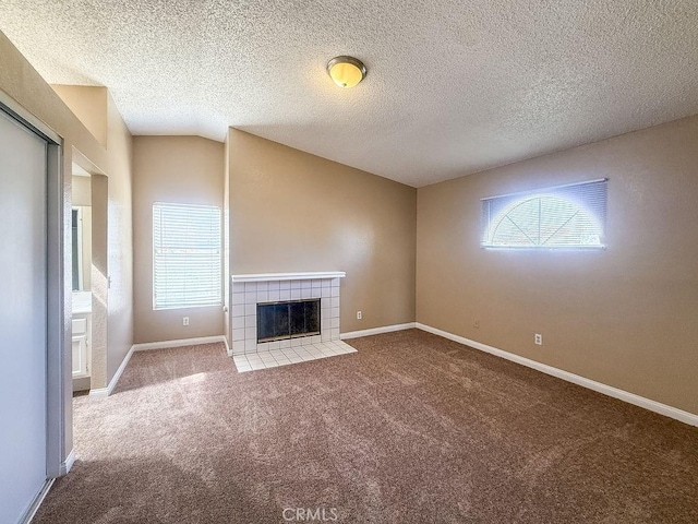 16702 Canoe Cv, Moreno Valley, CA 92551 - unfurnished living room with plenty of natural light, carpet flooring, a tile fireplace, and a textured ceiling
