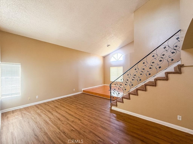 16702 Canoe Cv, Moreno Valley, CA 92551 - stairway with wood finished floors, a textured ceiling, and lofted ceiling