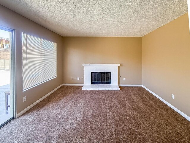 16702 Canoe Cv, Moreno Valley, CA 92551 - unfurnished living room with carpet floors, a textured ceiling, and a glass covered fireplace