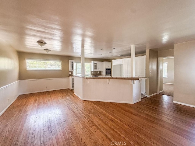 409 N Elwood Ave, Glendora, CA 91741 - kitchen with a breakfast bar, wood finished floors, white cabinetry, and oven