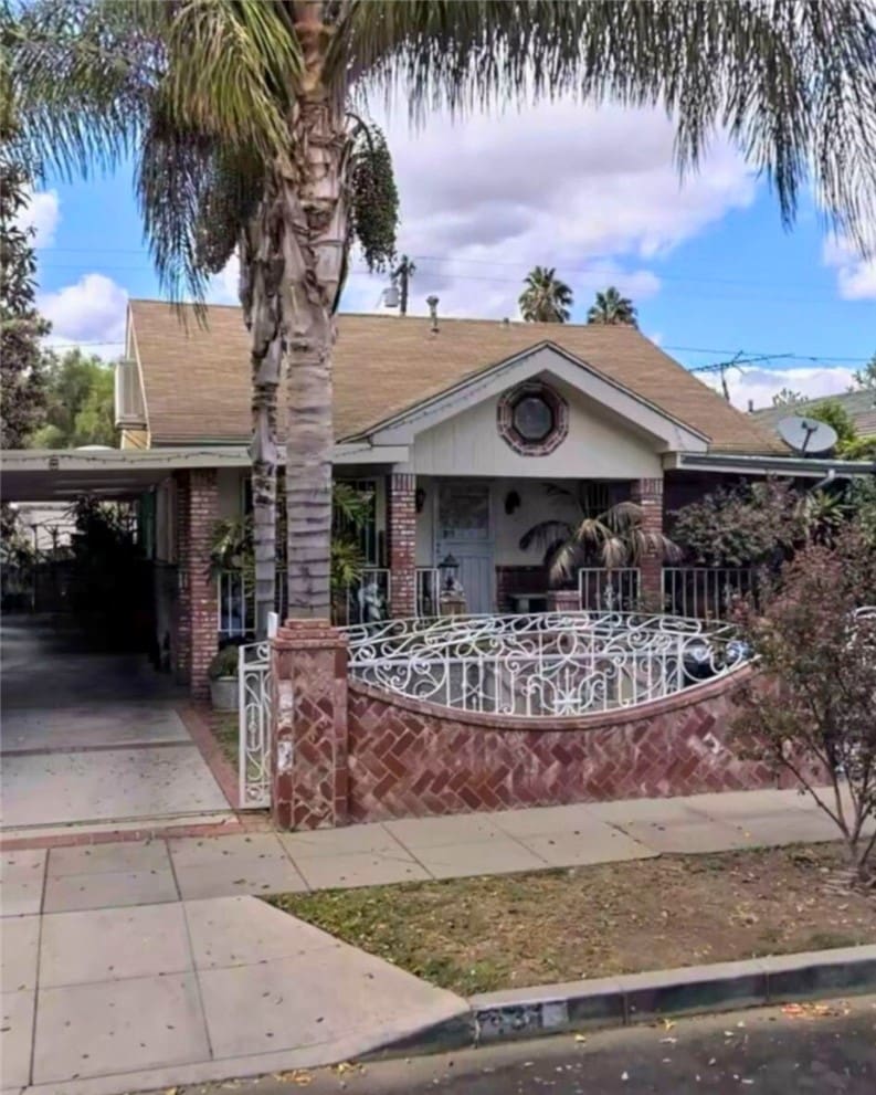 431 N Workman St, San Fernando, CA 91340 - bungalow-style house featuring concrete driveway, a fenced front yard, a carport, brick siding, and roof with shingles