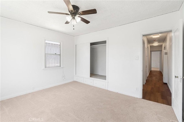 2027 W 70th St, Los Angeles, CA 90047 - unfurnished bedroom featuring carpet floors, a closet, a textured ceiling, and a ceiling fan