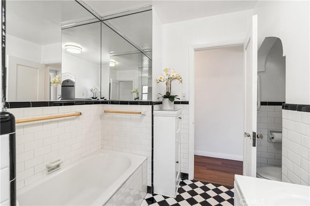 2027 W 70th St, Los Angeles, CA 90047 - full bathroom with tile patterned floors, vanity, tile walls, a tub to relax in, and wainscoting