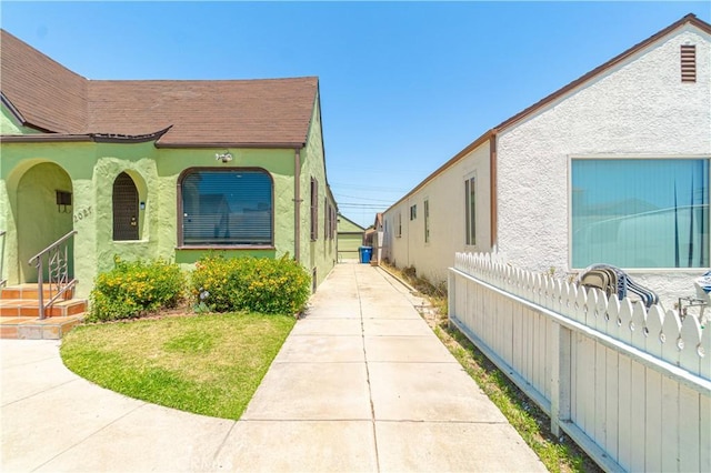 2027 W 70th St, Los Angeles, CA 90047 - view of side of home with stucco siding and roof with shingles