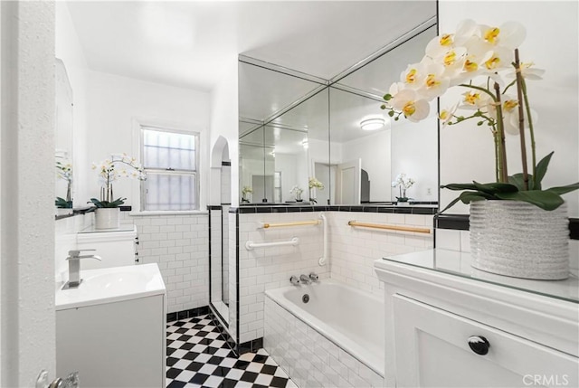 2027 W 70th St, Los Angeles, CA 90047 - bathroom with tile walls, vanity, a stall shower, a garden tub, and a wainscoted wall