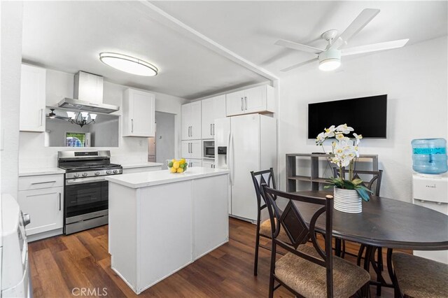 2027 W 70th St, Los Angeles, CA 90047 - kitchen featuring stainless steel appliances, wall chimney exhaust hood, dark wood finished floors, light countertops, and a kitchen island