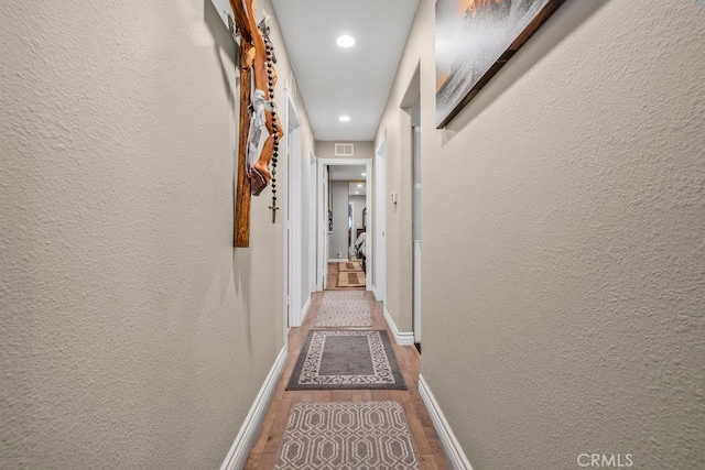 700 E Washington St Unit 143, Colton, CA 92324 - hallway featuring wood finished floors, a textured wall, and recessed lighting