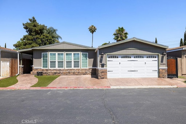 700 E Washington St Unit 143, Colton, CA 92324 - ranch-style home with stone siding, driveway, a garage, and a gate