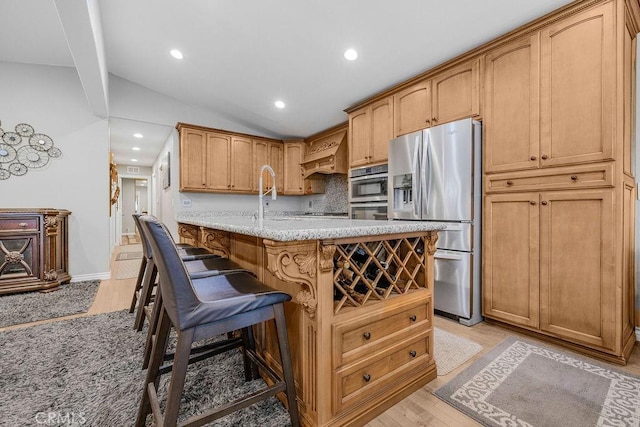 700 E Washington St Unit 143, Colton, CA 92324 - kitchen with appliances with stainless steel finishes, light wood-style flooring, recessed lighting, lofted ceiling, and a kitchen breakfast bar