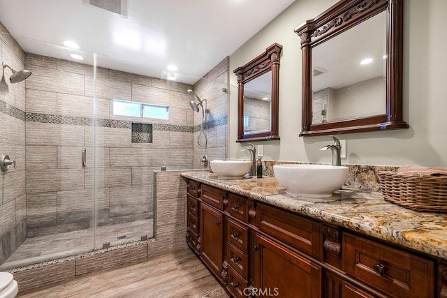 700 E Washington St Unit 143, Colton, CA 92324 - bathroom featuring a shower stall, double vanity, wood finished floors, and recessed lighting