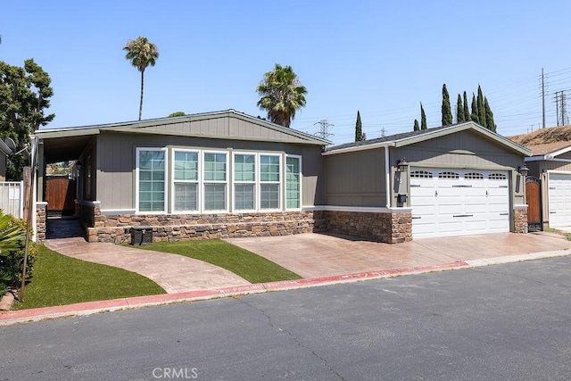 700 E Washington St Unit 143, Colton, CA 92324 - view of front of house featuring stone siding, concrete driveway, and an attached garage