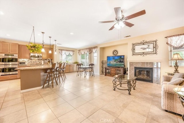 19247 Mountain Shadow Ln, Perris, CA 92570 - living room with a glass covered fireplace, a ceiling fan, light tile patterned flooring, and recessed lighting