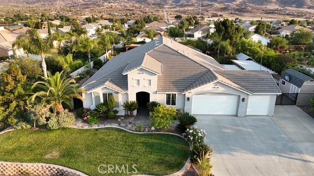 19247 Mountain Shadow Ln, Perris, CA 92570 - mediterranean / spanish-style home featuring a tiled roof, a garage, driveway, a front yard, and stucco siding
