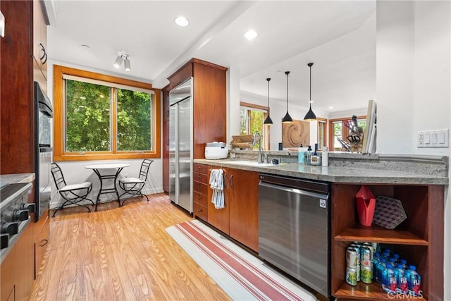 411 N Oakhurst Dr Unit 201, Beverly Hills, CA 90210 - kitchen featuring stainless steel appliances, light wood finished floors, light stone counters, brown cabinets, and pendant lighting