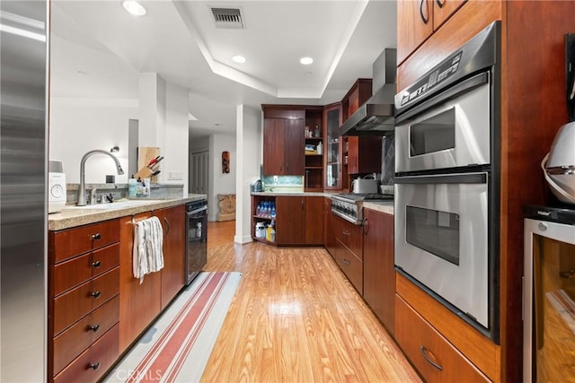 411 N Oakhurst Dr Unit 201, Beverly Hills, CA 90210 - kitchen with wall chimney exhaust hood, appliances with stainless steel finishes, light wood-type flooring, beverage cooler, and recessed lighting