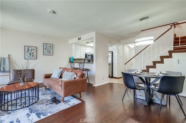 7302 Bright Ave Unit B, Whittier, CA 90602 - living area with dark wood-style flooring, stairway, and a textured ceiling