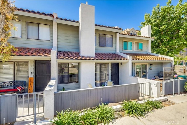 7302 Bright Ave Unit B, Whittier, CA 90602 - mediterranean / spanish home with a chimney, a fenced front yard, a tiled roof, and stucco siding