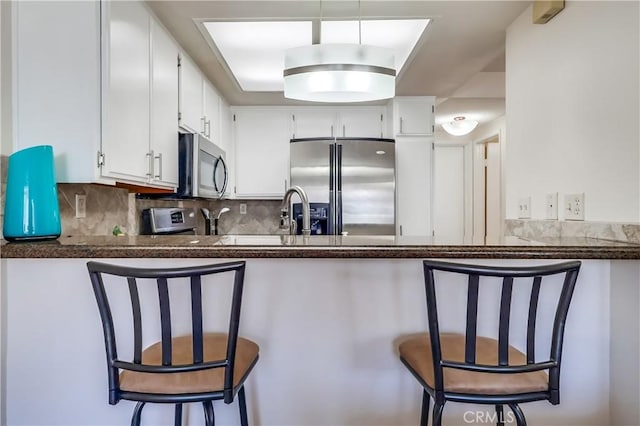 7302 Bright Ave Unit B, Whittier, CA 90602 - kitchen featuring dark countertops, appliances with stainless steel finishes, a peninsula, and tasteful backsplash