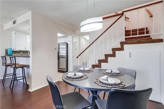 7302 Bright Ave Unit B, Whittier, CA 90602 - dining room featuring stairs, dark wood-type flooring, and a textured ceiling