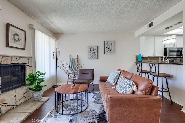 7302 Bright Ave Unit B, Whittier, CA 90602 - living room with a textured ceiling, dark wood-type flooring, and a fireplace