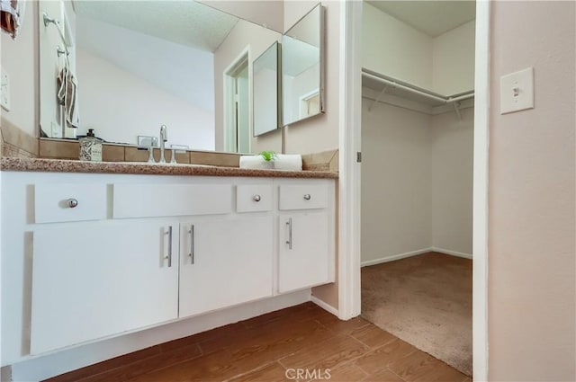 7302 Bright Ave Unit B, Whittier, CA 90602 - bathroom featuring vanity, a spacious closet, and wood finished floors