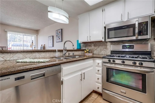 7302 Bright Ave Unit B, Whittier, CA 90602 - kitchen with appliances with stainless steel finishes, decorative backsplash, white cabinets, dark stone counters, and a textured ceiling