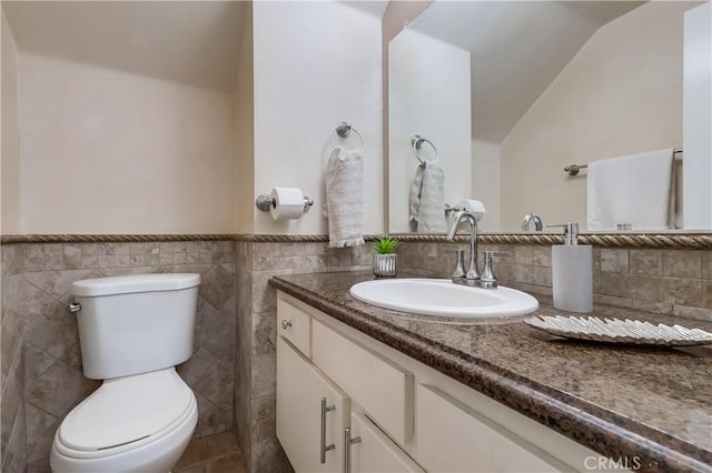 7302 Bright Ave Unit B, Whittier, CA 90602 - bathroom with lofted ceiling, vanity, a wainscoted wall, and tile walls