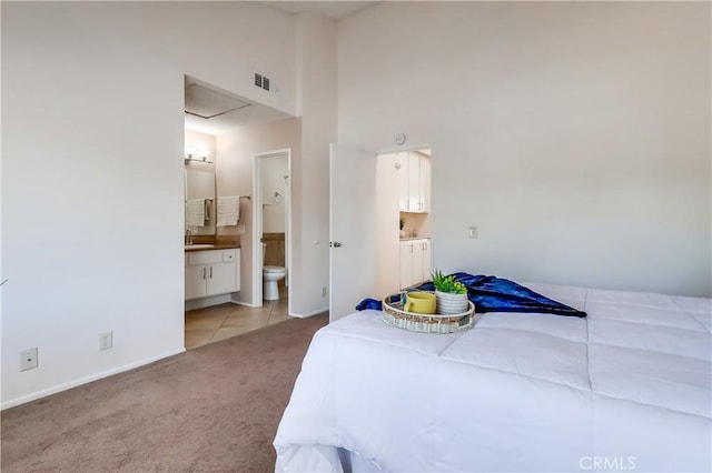 7302 Bright Ave Unit B, Whittier, CA 90602 - bedroom featuring connected bathroom, light carpet, a high ceiling, and light tile patterned floors