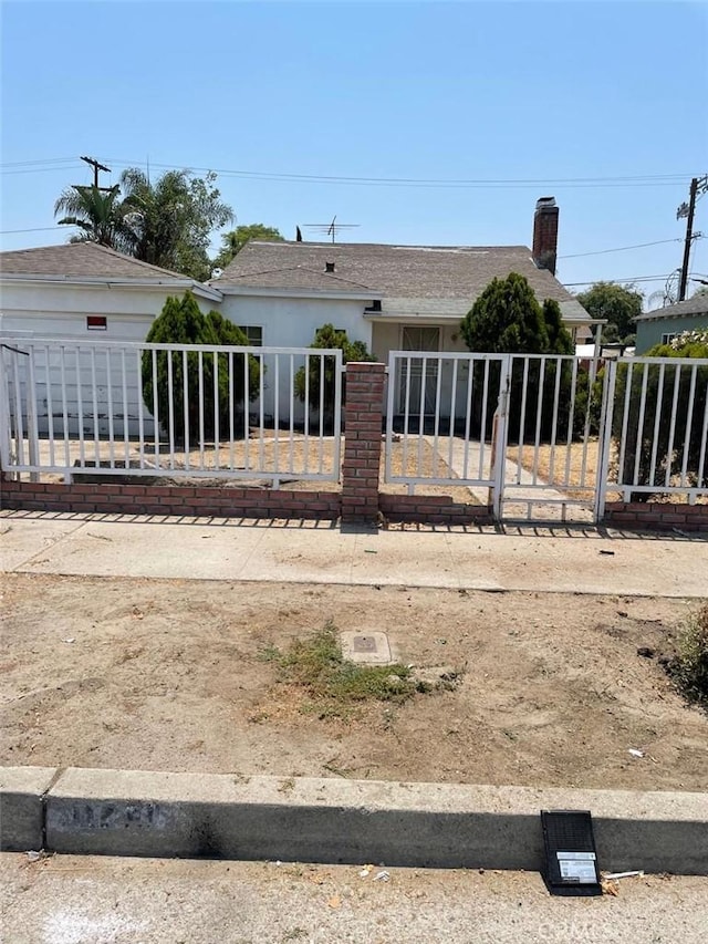 11250 Victory Blvd, North Hollywood, CA 91606 - rear view of house with a fenced front yard, a chimney, stucco siding, and a gate