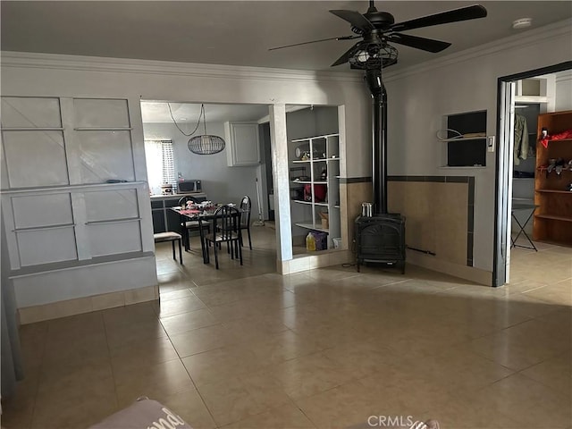 3938 Kreuer Rd, Phelan, CA 92371 - living room with crown molding, a wood stove, ceiling fan, and tile patterned flooring