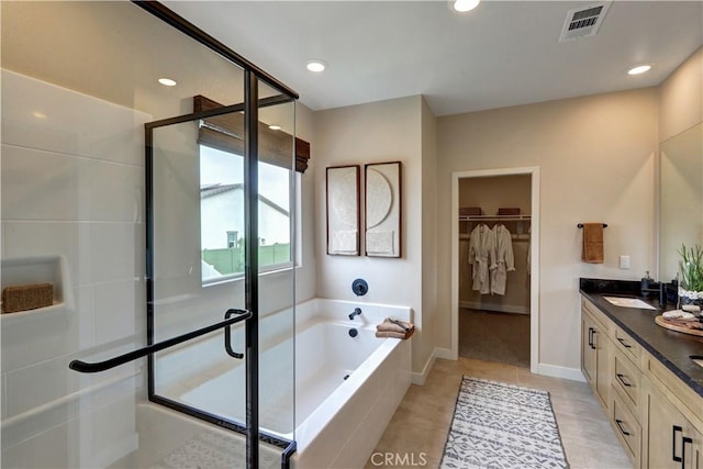 17163 Kent St, Hesperia, CA 92345 - bathroom featuring double vanity, a bath, a stall shower, a walk in closet, and tile patterned flooring