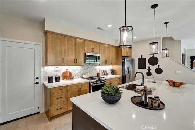 17163 Kent St, Hesperia, CA 92345 - kitchen featuring stainless steel appliances, decorative backsplash, light countertops, pendant lighting, and brown cabinets