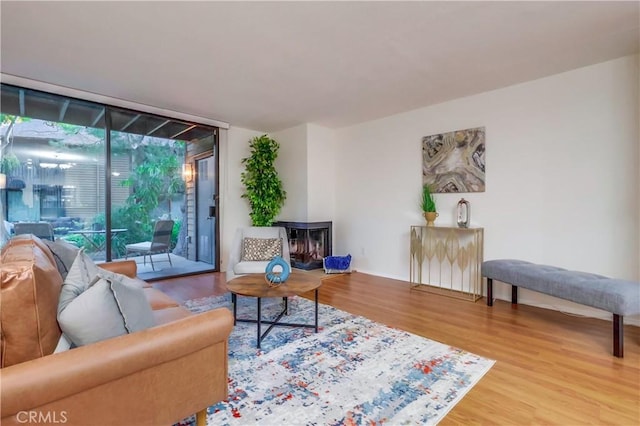 4140 Workman Mill Rd Unit 78, Whittier, CA 90601 - living room with expansive windows, wood finished floors, and a multi sided fireplace
