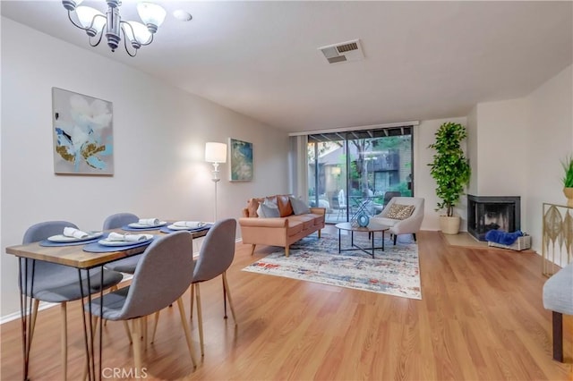 4140 Workman Mill Rd Unit 78, Whittier, CA 90601 - dining space with light wood-type flooring, a chandelier, and a multi sided fireplace