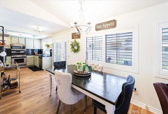 5260 W Palmer Dr, Banning, CA 92220 - dining space with a chandelier, plenty of natural light, vaulted ceiling, light wood-style flooring, and french doors