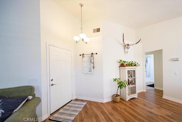 5260 W Palmer Dr, Banning, CA 92220 - foyer featuring wood finished floors, high vaulted ceiling, and a chandelier