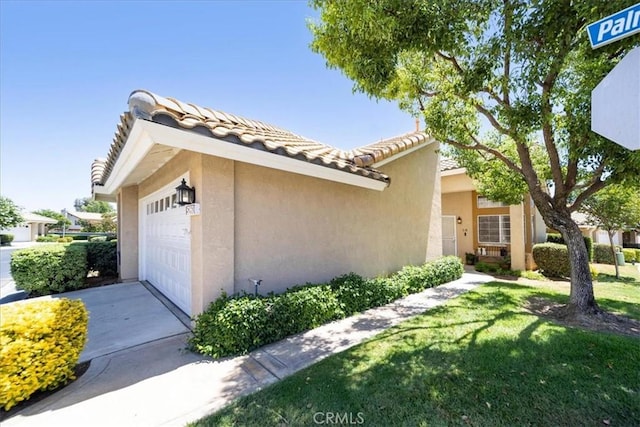 5260 W Palmer Dr, Banning, CA 92220 - view of front of home with stucco siding, a garage, a front yard, and a tile roof
