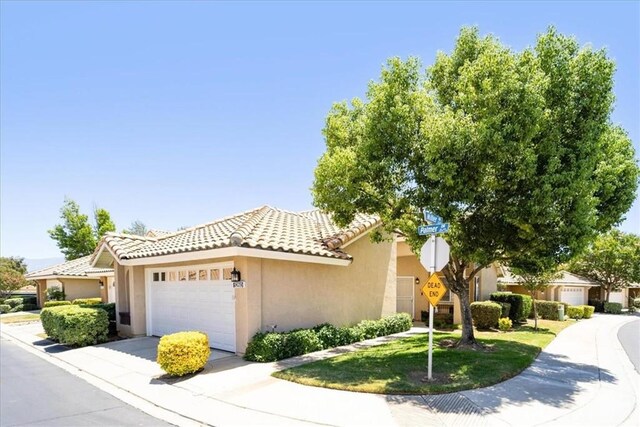 5260 W Palmer Dr, Banning, CA 92220 - view of front facade with a garage, stucco siding, a tile roof, and driveway
