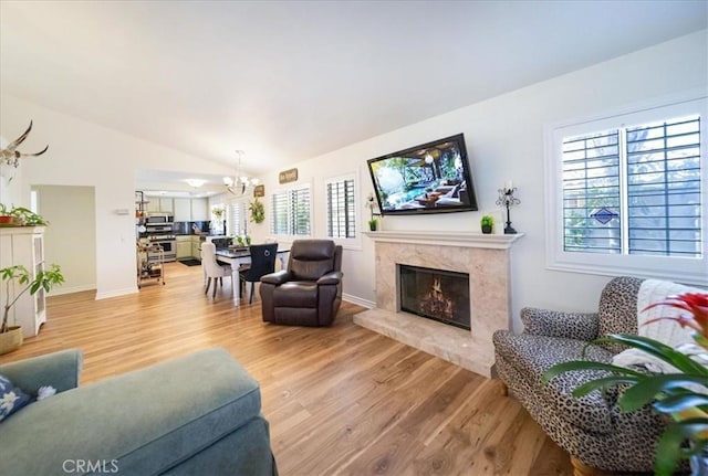 5260 W Palmer Dr, Banning, CA 92220 - living room featuring a chandelier, light wood-type flooring, a premium fireplace, and lofted ceiling