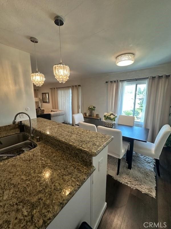 450 W Vermont Ave Unit 1104, Escondido, CA 92025 - kitchen with dark wood-type flooring, stone countertops, a chandelier, and pendant lighting