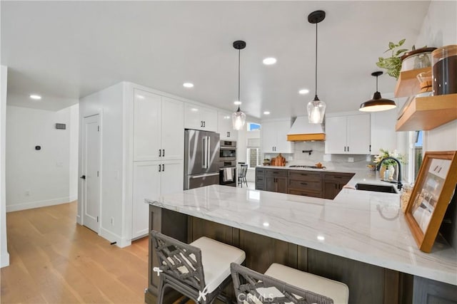 5025 Stonehaven Dr, Yorba Linda, CA 92887 - kitchen featuring a peninsula, stainless steel appliances, light wood finished floors, white cabinets, and custom range hood