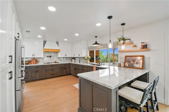 5025 Stonehaven Dr, Yorba Linda, CA 92887 - kitchen with premium range hood, a peninsula, light wood-type flooring, stainless steel refrigerator, and gas stovetop