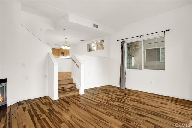 4600 Don Lorenzo Dr Unit 20, Los Angeles, CA 90008 - unfurnished living room with wood finished floors, a chandelier, stairway, and a glass covered fireplace